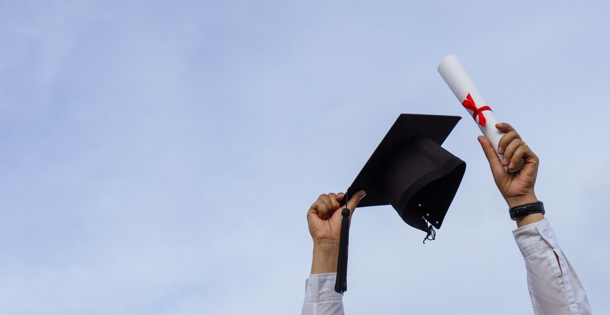 Graduation day,A certificate and a mortar board in hand with sky background,,Congratulation.